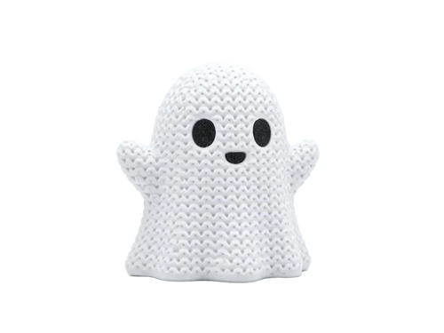 A white knitted ghost figurine with black embroidered eyes and a small black smile, standing against a seamless light gray background.